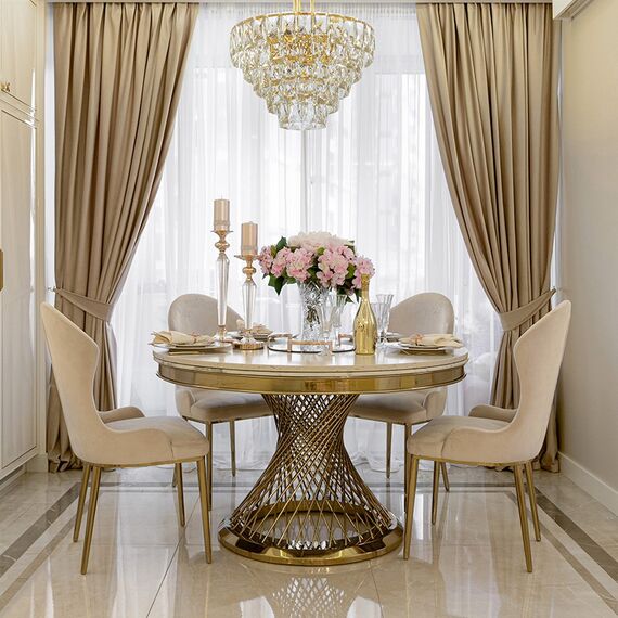 Ekskluzywny stół okrągły Antonio ze złotą podstawą i marmurowym blatem.