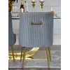 Ekspozycja designerskiego krzesła tapicerowanego, z kołatką, w showroomie Primavera Home, idealnego do nowoczesnych wnętrz.