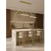 Lampa Złota Nowoczesna Nad Stół na ekspozycji w showroomie, z pełnym uwydatnieniem jej unikalnego designu. Meble na zamówienie od Primavera Home.