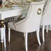 Ekskluzywne krzesło do jadalni, pikowane, z kołatką, glamour, nowojorskie, drewniany stelaż, nowoczesne, złote PRINCE w ekspozycji w showroomie. Nowoczesność od Primavera Home.
