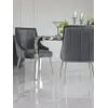 Bliskie ujęcie designerskiego stołu glamour ze szklanym blatem, stalowego, nowoczesnego, srebrnego ELITE, oświetlonego naturalnym światłem, oferowanego przez Primavera Home.