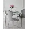 Szeroki widok z daleka na designerski stół glamour ze szklanym blatem, stalowy, nowoczesny, srebrny ELITE, prezentujący się efektownie w przestrzeni od Primavera Home.