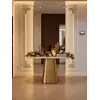 Złota Konsola Belissima Szczotkowane Złoto Blat Patagonia Premium prezentowana w luksusowym showroomie, skupiająca uwagę na detalach konstrukcji. Aranżacja nowoczesnego wnętrza od Primavera Home.
