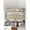 Żyrandol Kryształowy Bulgari XL Złoty Dwupoziomowy w ekspozycji w showroomie, w otoczeniu stylowych mebli. Oświetlenie na zamówienie od Primavera Home.