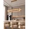 Elegancki żyrandol kryształowy złoty nowoczesny owalny w aranżacji nowoczesnego wnętrza. Lampa wisząca ECLIPSE od Primavera Home.