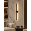 Czarny kinkiet w aranżacji nowoczesnego wnętrza salonu, podkreślający elegancję przestrzeni. Produkt od Primavera Home.