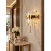 Kinkiet kryształowy złoty w ekspozycji showroomowej, lampa ścienna glamour BULGARI prezentująca nowoczesny design. Oświetlenie na zamówienie od Primavera Home.