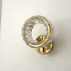 Kinkiet Kryształowy Ring Złoty Eclipse w stylowej ekspozycji w salonie. Oświetlenie od Primavera Home.