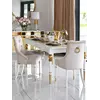 Stół Queen glamour z białym blatem i złotymi detalami w eleganckiej jadalni Primavera Home, otoczony jasnymi krzesłami i dekoracjami kwiatowymi.