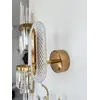 Kinkiet w złotym kolorze zlokalizowany w nowoczesnej łazience, idealny wybór od Primavera Home.