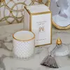 Decorative scented candle in a white and gold crystal glass container