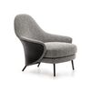 Modern, upholstered designer armchair on black legs with a LINEA footstool