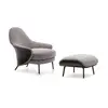 Modern, upholstered designer armchair on black legs with a LINEA footstool