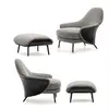 Modern, upholstered designer armchair on black legs with a LINEA footstool