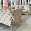 Sofa ze złotą stalową nogą w aranżacji luksusowego salonu glamour