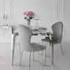Designerski stół glamour ze szklanym blatem ustawiony przy oknie, tworzący harmonijną przestrzeń. Meble na zamówienie od Primavera Home.
