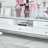 Komoda RTV glamour wysoki połysk biało srebrna Lorenzo L Silver na tle szarej ściany. Meble na zamówienie od PRIMAVERA HOME.