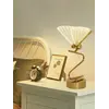 Widok Lampy Stołowej Motyl Złota umieszczonej na eleganckim stole. Ekspozycja w salonie od Primavera Home.