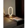 Lampa stołowa umieszczona na eleganckim stole, podkreślająca jego urok. Aranżacja nowoczesnego wnętrza od Primavera Home.
