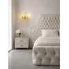 Łóżko glamour tapicerowane pikowane w ekspozycji showroomowej, prezentujące swoje wyjątkowe cechy. Oświetlenie na zamówienie od Primavera Home.