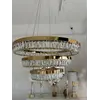 Perspektywiczne ujęcie żyrandola kryształowego złotego BELLINI XL w eleganckim wnętrzu. Lampa od Primavera Home.