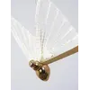 Żyrandol Motyl M Złoty uchwycony w poziomie, eksponujący jego elegancki kształt. Aranżacja nowoczesnego wnętrza od Primavera Home.