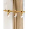 Lampa wisząca w jasnym wnętrzu, podkreślająca przestronność. Ekspozycja w salonie od Primavera Home.