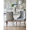 Luksusowe krzesło glamour, pikowane z kołatką, do jadalni, na stalowych, prostych nogach, szare, srebrne MADAME w ujęciu z przodu. Oświetlenie na zamówienie od Primavera Home.