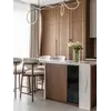 Ekspozycja w otwartym salonie z Designerskim Hokerem Drewnianym Olivia – Krzesło Barowe od Primavera Home.