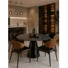 Okrągły Stół do Jadalni Oslo Spiekany kamień czarny Carrara i Stal Premium w wieczornym oświetleniu wnętrza. Ekspozycja w salonie od Primavera Home.