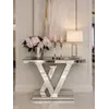 Konsola lustrzana galmour srebrna nowoczesna LV umieszczona w jasnym wnętrzu, dodająca blasku i elegancji. Meble na zamówienie od Primavera Home.