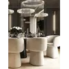 Nowoczesne Krzesło Obrotowe Dolce – Tapicerowane i Designerskie na tle stołu, eksponujące atrakcyjny design. Aranżacja nowoczesnego wnętrza od Primavera Home.