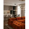 Perspektywa miejsca siedzącego z designerskim narożnikiem modułowym boucle NICEA w przestronnym salonie. Oferowane przez Primavera Home.