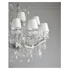 Zestawienie żyrandola z różnymi elementami dekoracyjnymi, podkreślającymi jego elegancję. Oświetlenie od Primavera Home.