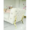 Luksusowa złota sofa pikowana DIVA GOLD w aranżacji z detalem ekspozycji. Aranżacja nowoczesnego wnętrza od Primavera Home.