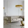 Luksusowa złota sofa pikowana DIVA GOLD w ujęciu z przodu. Oświetlenie na zamówienie od Primavera Home.
