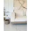 Sofa narożna z półką w ciepłym wnętrzu, tworząca przytulną atmosferę, prezentująca nowoczesny styl od Primavera Home.