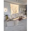 Sofa narożna z półką umiejscowiona w rogu salonu, tworząca przyjemną atmosferę od Primavera Home.