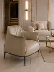 Nowoczesny wygodny fotel luksusowy do salonu z podnóżkiem MODERN w ujęciu z przodu. Oświetlenie w aranżacji od Primavera Home.