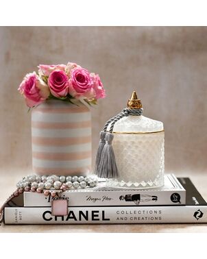 Decorative scented candle in a white and gold crystal glass container