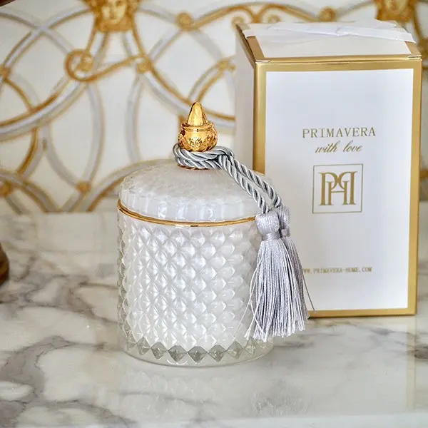 Decorative scented candle in a white and gold crystal glass container