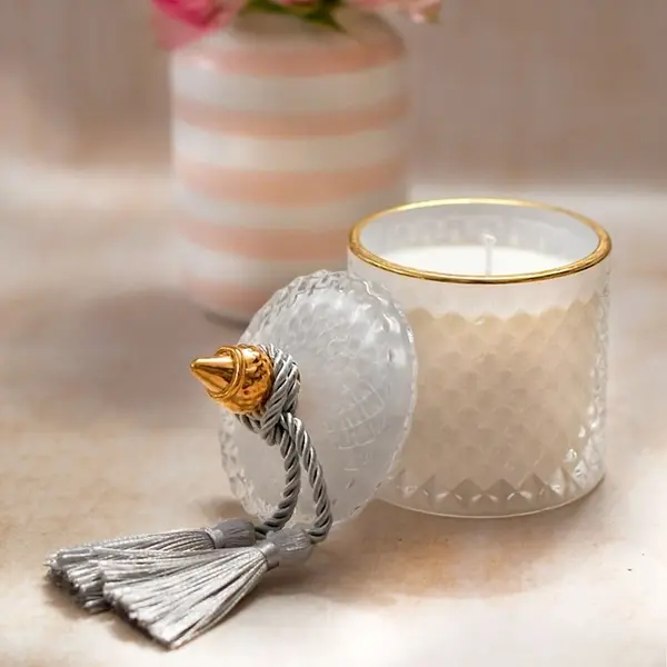 Decorative scented candle in a white and gold crystal glass container