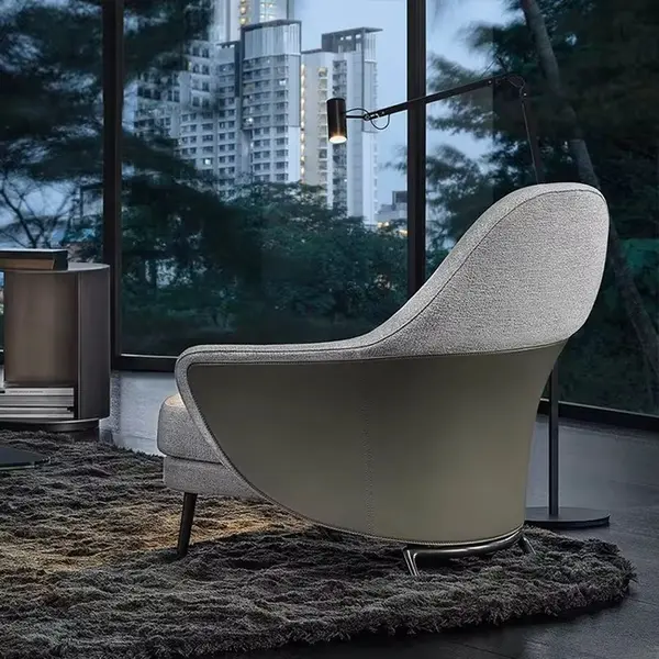 Modern, upholstered designer armchair on black legs with a LINEA footstool