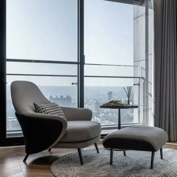 Modern, upholstered designer armchair on black legs with a LINEA footstool