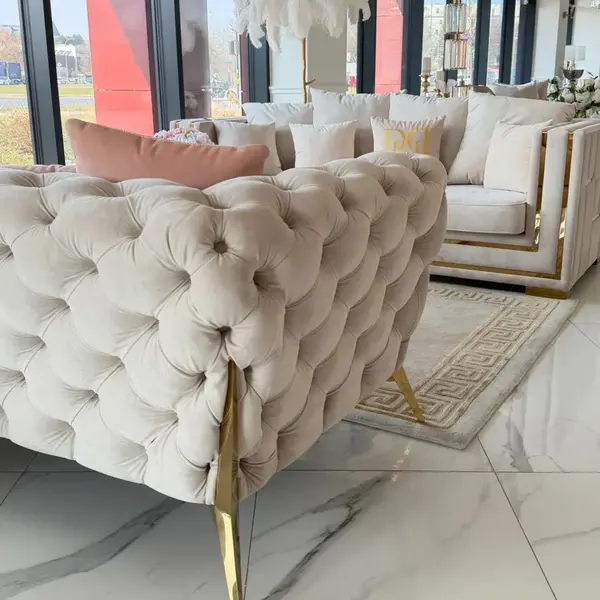 Sofa ze złotą stalową nogą w aranżacji luksusowego salonu glamour