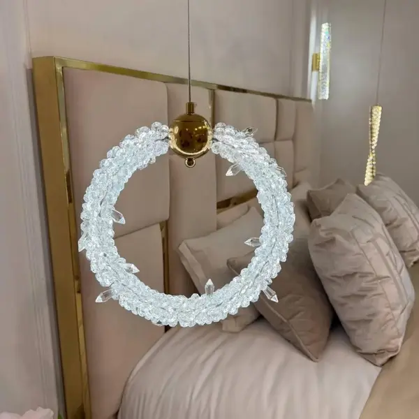 Lampa wisząca kryształowa złota ICE XS emitująca światło w salonie, projekt od Primavera Home.