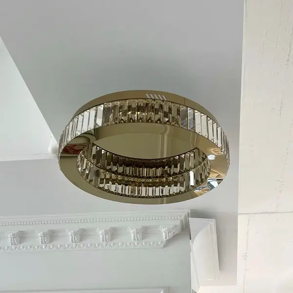 Aranżacja złotego plafonu kryształowego Eclipse w nowoczesnym salonie. Mebel od Primavera Home.
