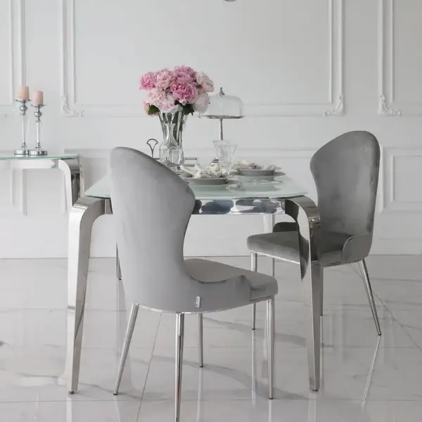 Designerski stół glamour ze szklanym blatem ustawiony przy oknie, tworzący harmonijną przestrzeń. Meble na zamówienie od Primavera Home.