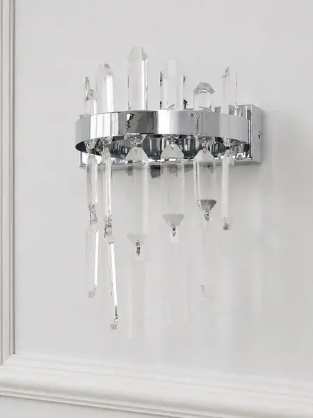 Kinkiet kryształowy srebrny Bulgari z detalami światła w tle. Lampa od Primavera Home.