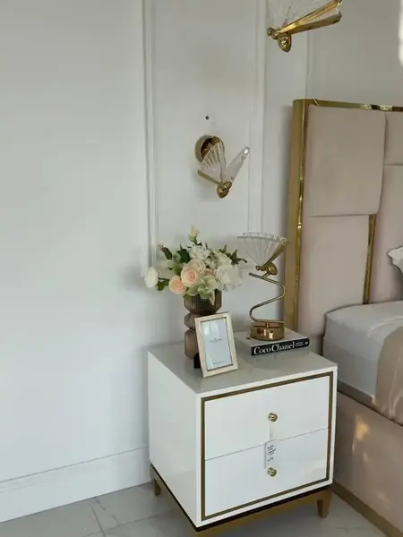 Kinkiet Motyl Złoty stylizowany na szafce. Ekspozycja w salonie od Primavera Home.